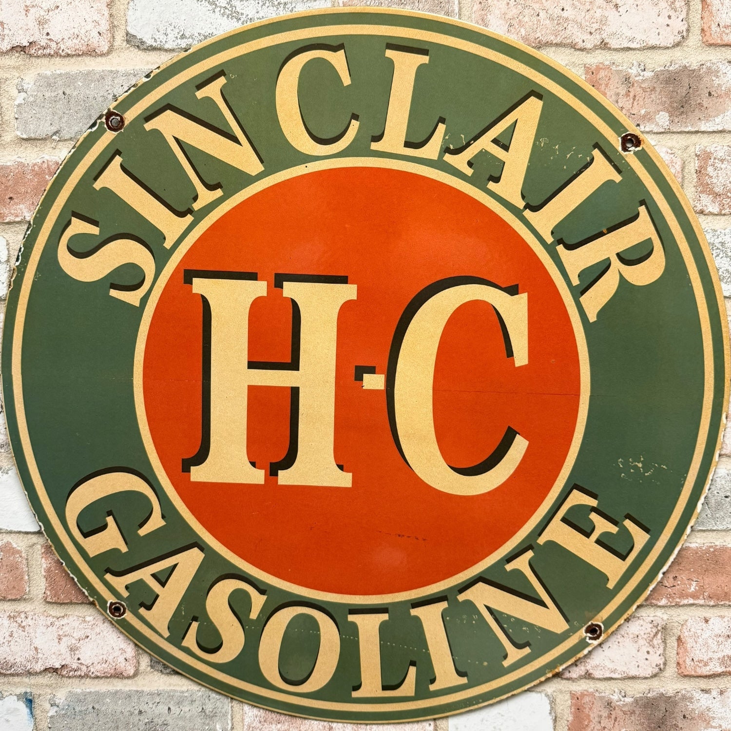Vintage Sinclair H-C Gasoline sign on a brick wall background