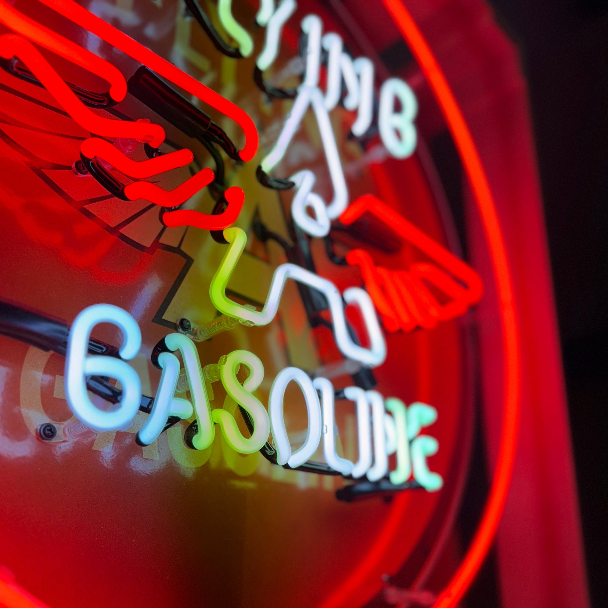 Neon sign with 'Flying-A Gasoline' text showing the letters and words in white glowing neon with the focal point being an icon with letter A that has red wings protruding from the sides of the white letter A
