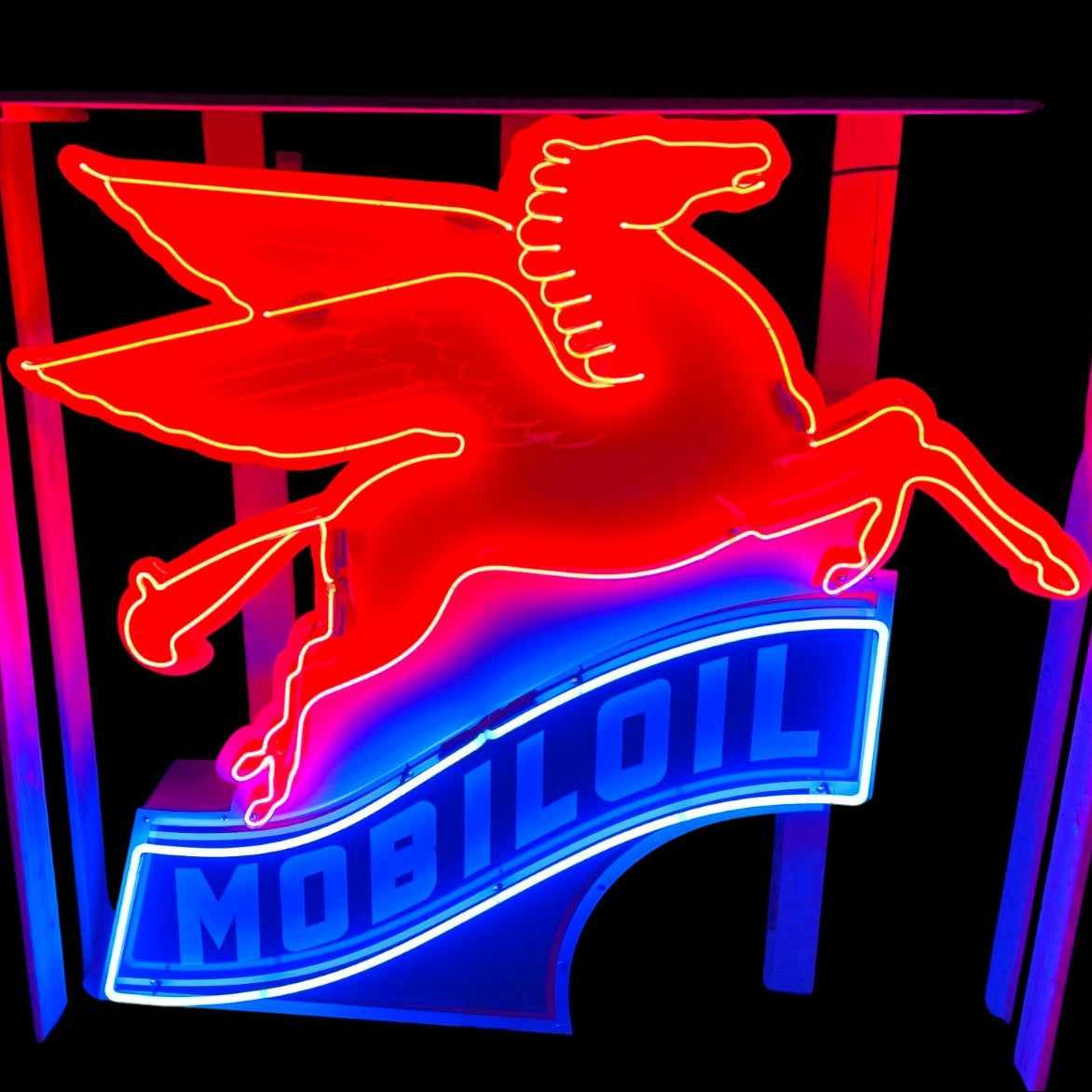 Neon sign of a winged horse logo with 'Mobil Oil' text on a black background