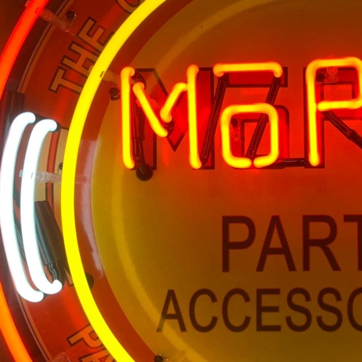 Close-up of illuminated Mopar neon sign with glowing red and yellow hand-blown glass