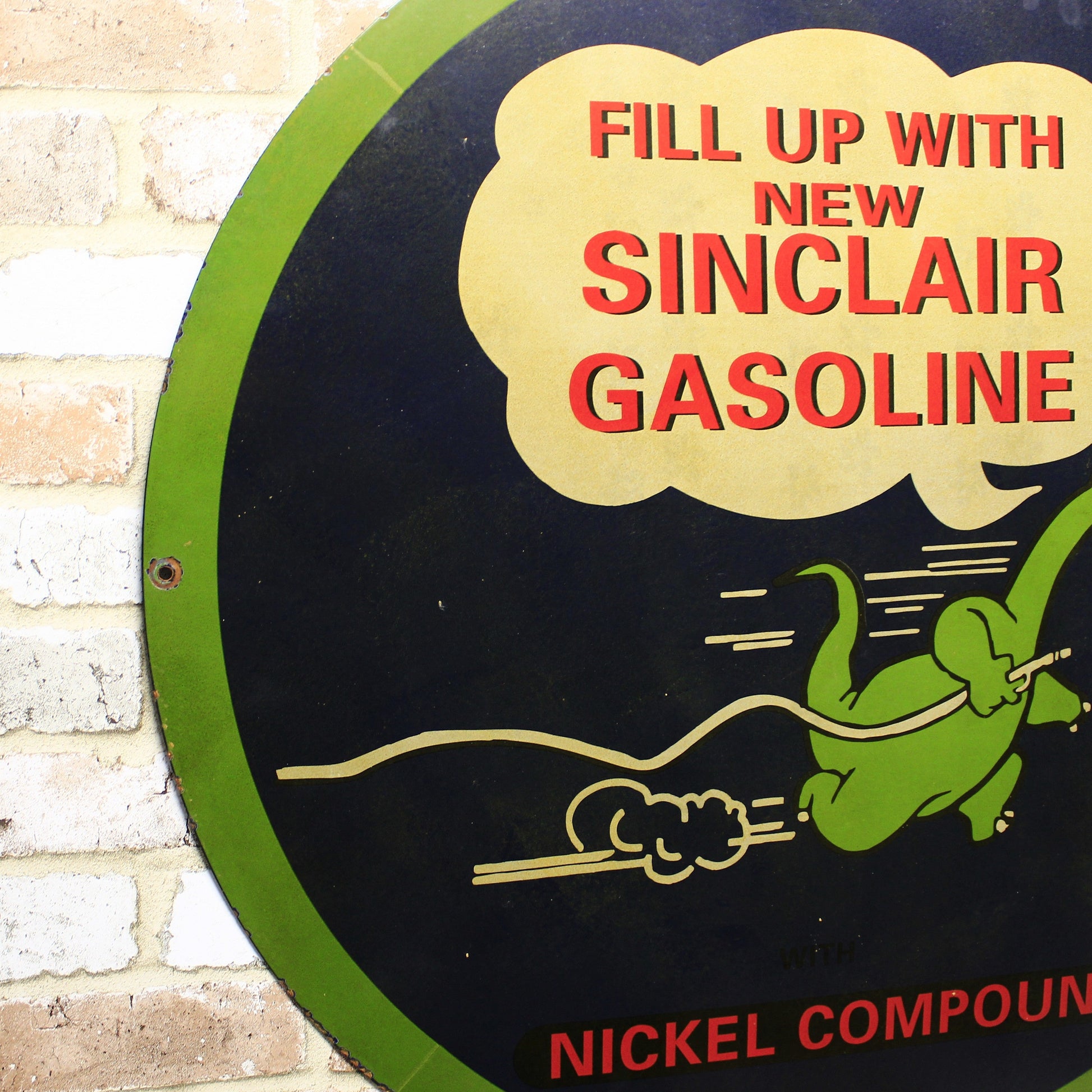 Vintage Sinclair Gasoline sign with a green dinosaur illustration on a brick wall background.