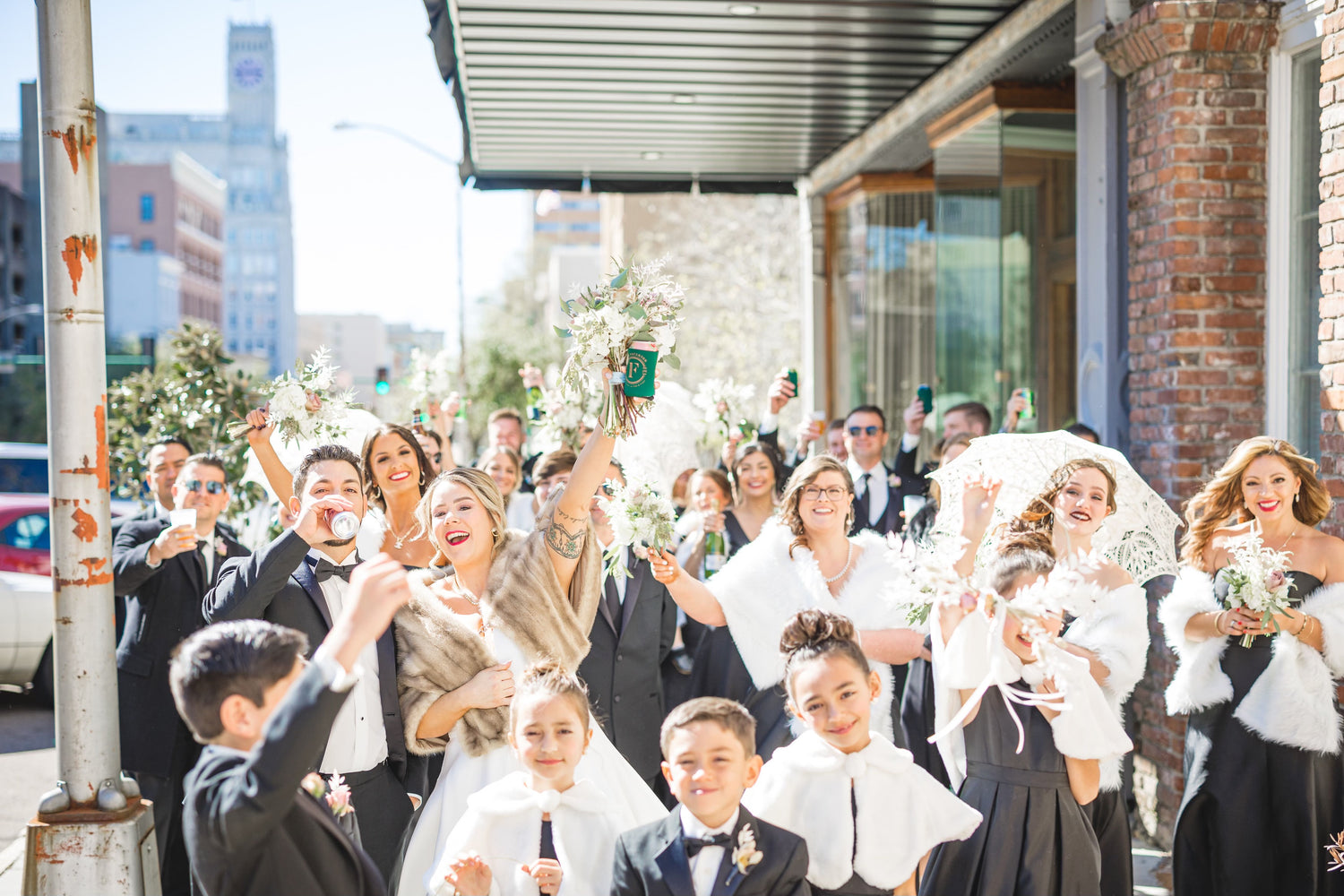 Picture of the owner founder of Porcelain Advertising, Darrien Eouse celebrating on the streets of Mississippi with his beautiful new wife Kayla Caldwell Eouse surrounded by friends and family everyone cheering and toasting