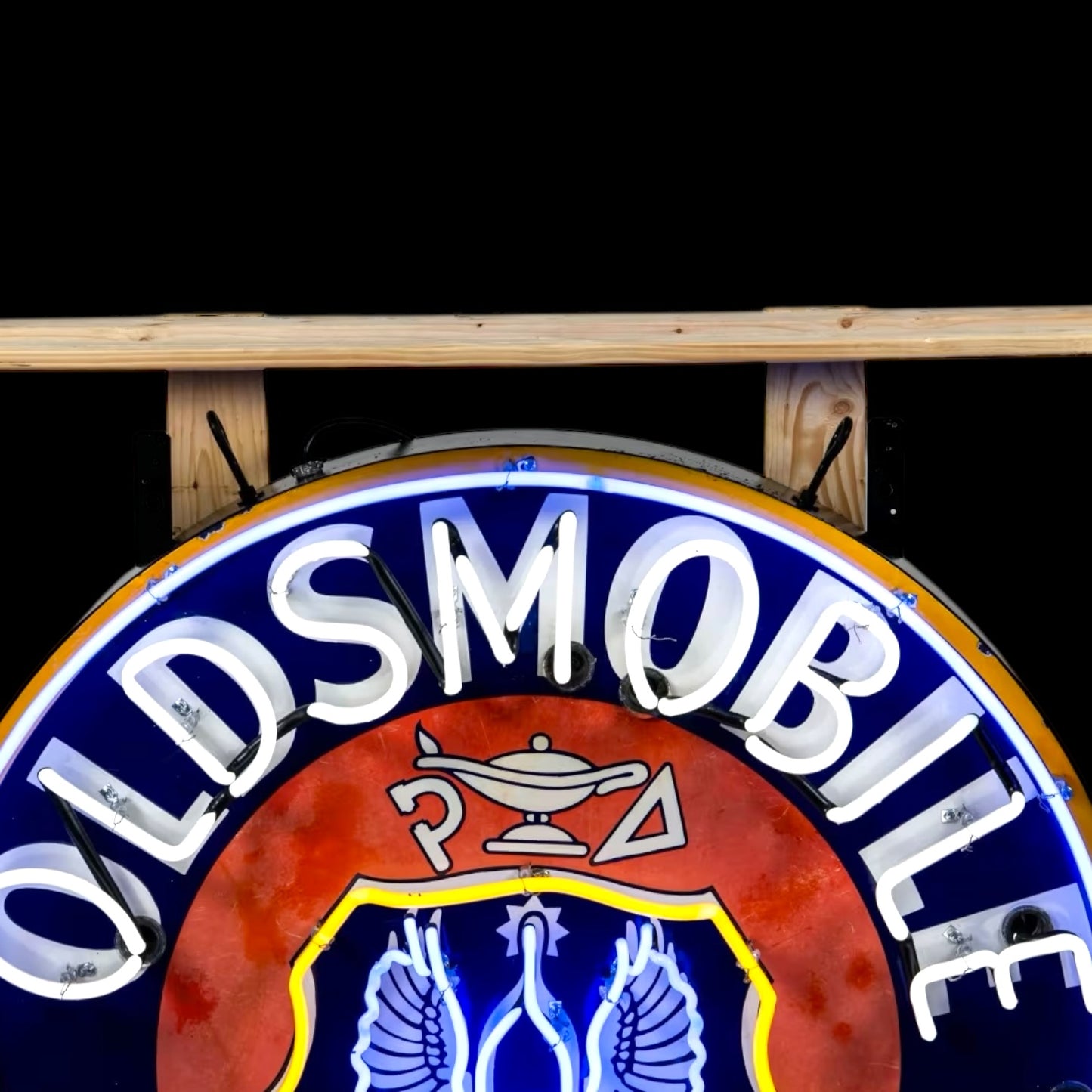 close up of top of unlit neon sign with oldsmobike and genie bittke