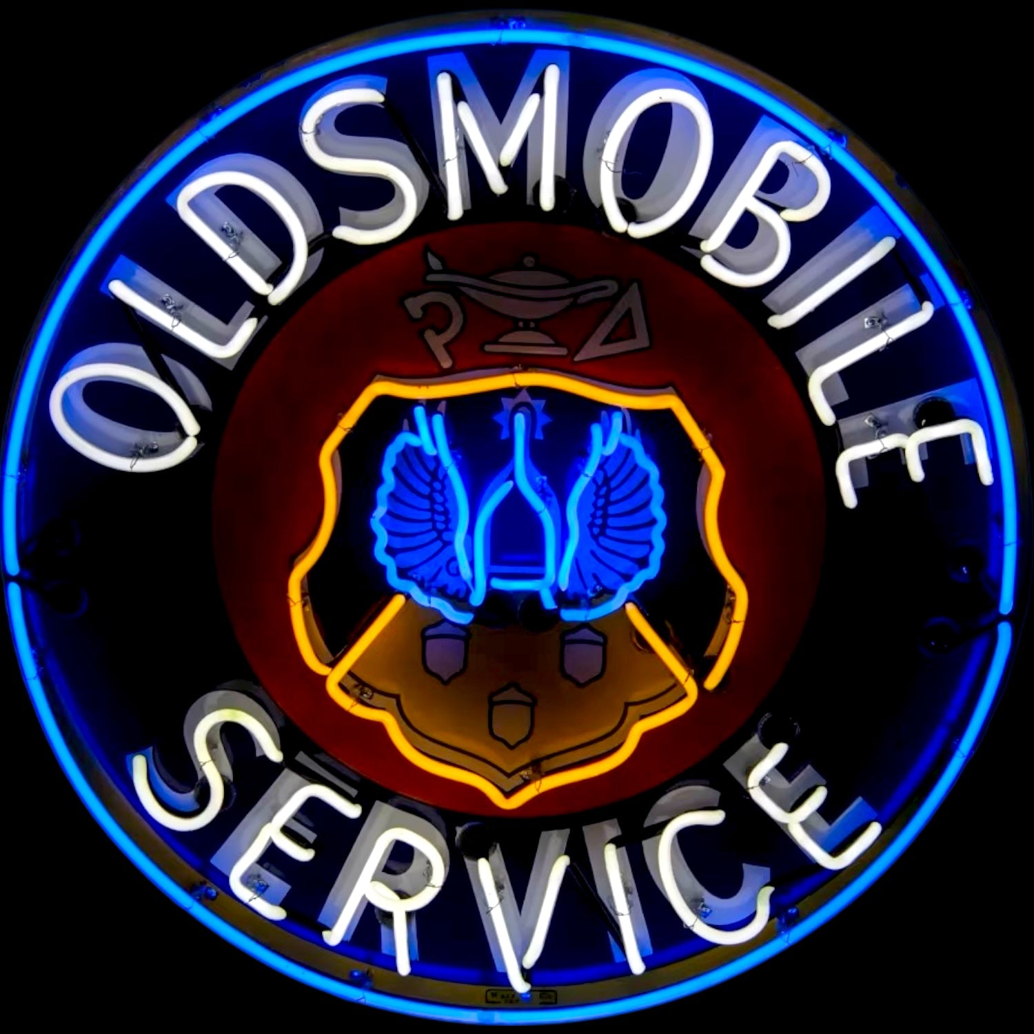 Neon sign with 'Oldsmobile Service' text and logo on a black background